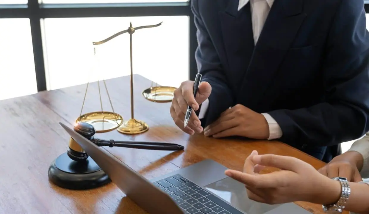 Business and lawyers discussing contract papers with brass scale on desk in office. Law, legal