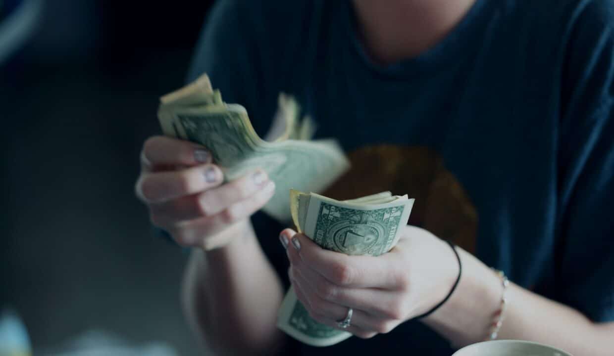 focus photography of person counting dollar banknotes