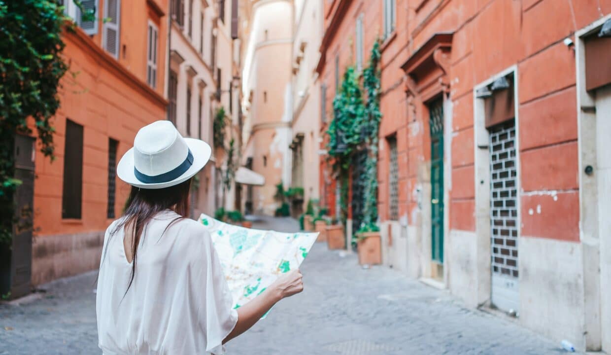 Travel tourist woman with map in Rome outdoors during holidays in Europe