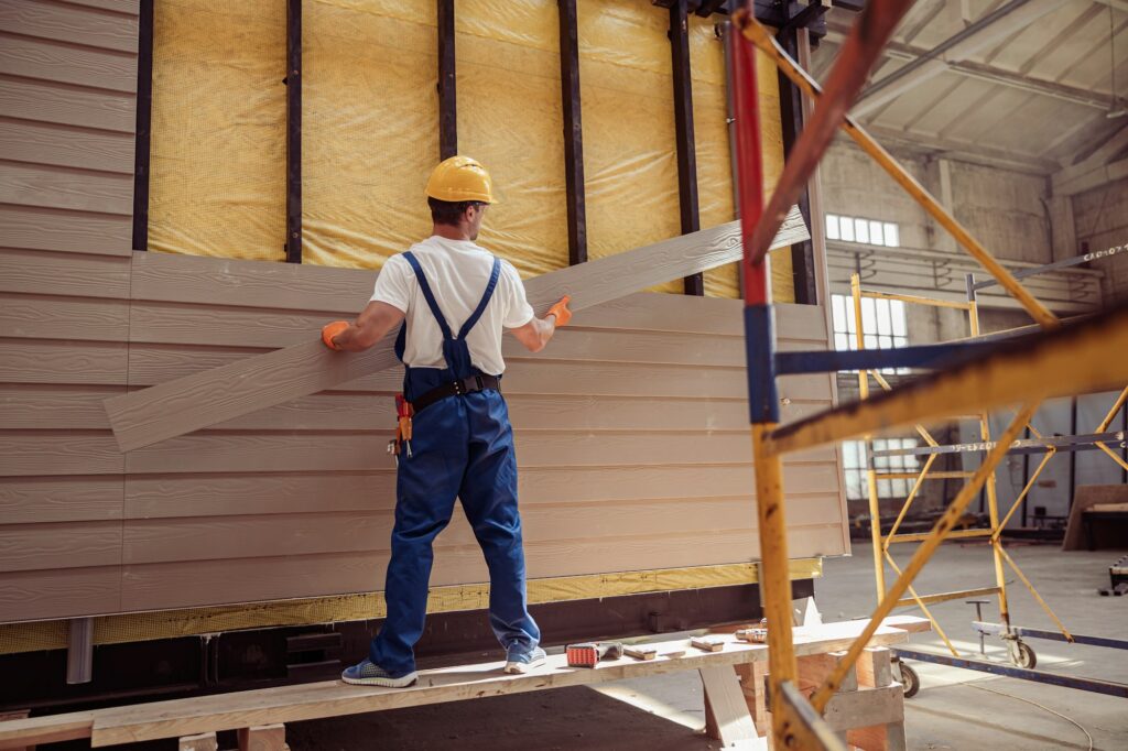 Male worker building house at construction site