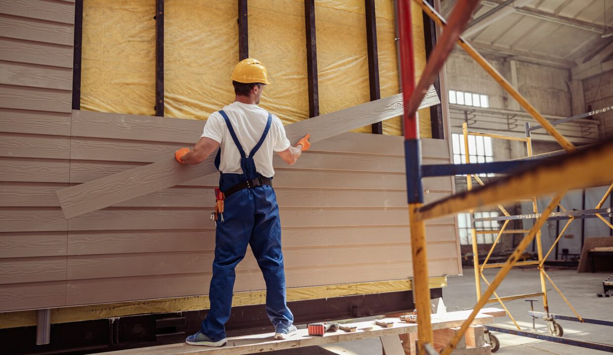 Male worker building house at construction site